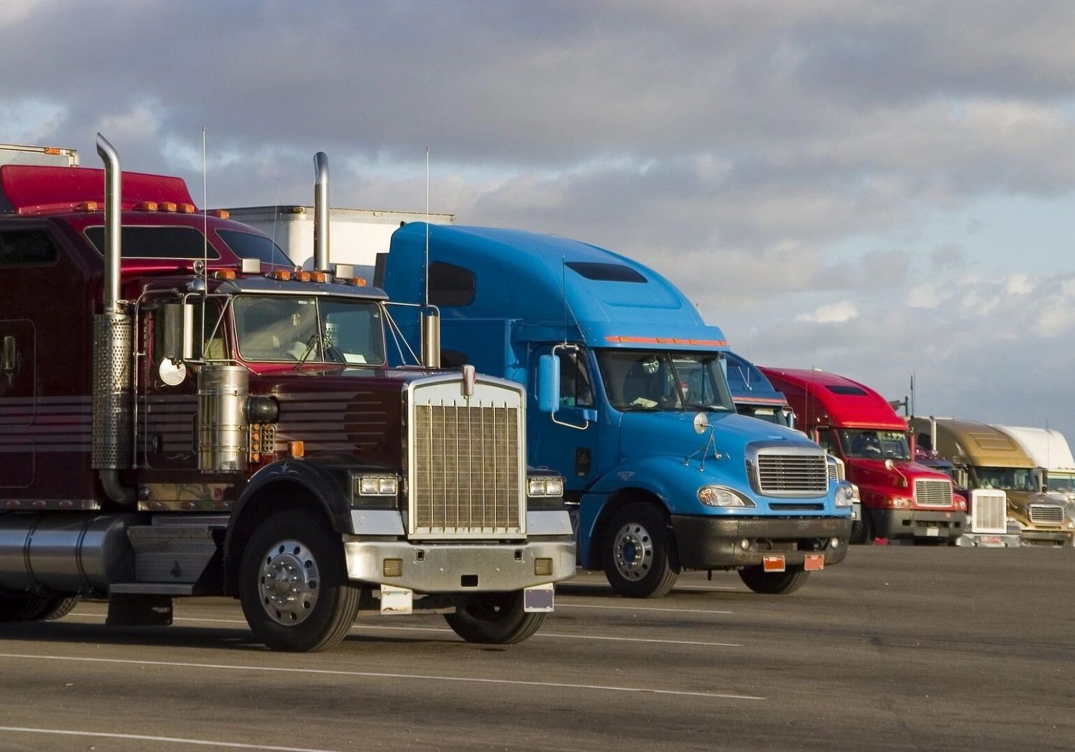 A group of trucks are parked in the street.