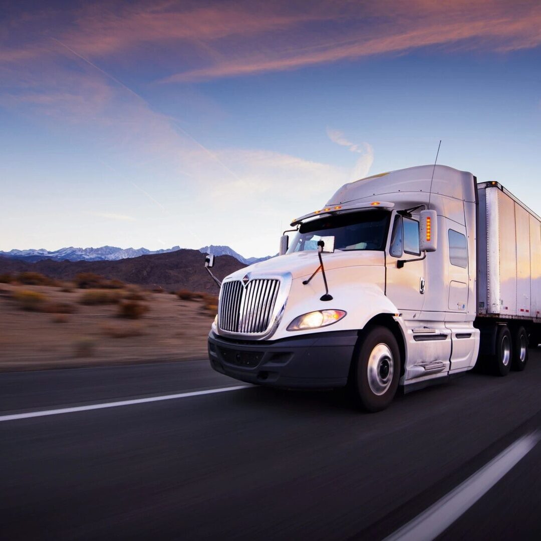 A white semi truck driving down the road.